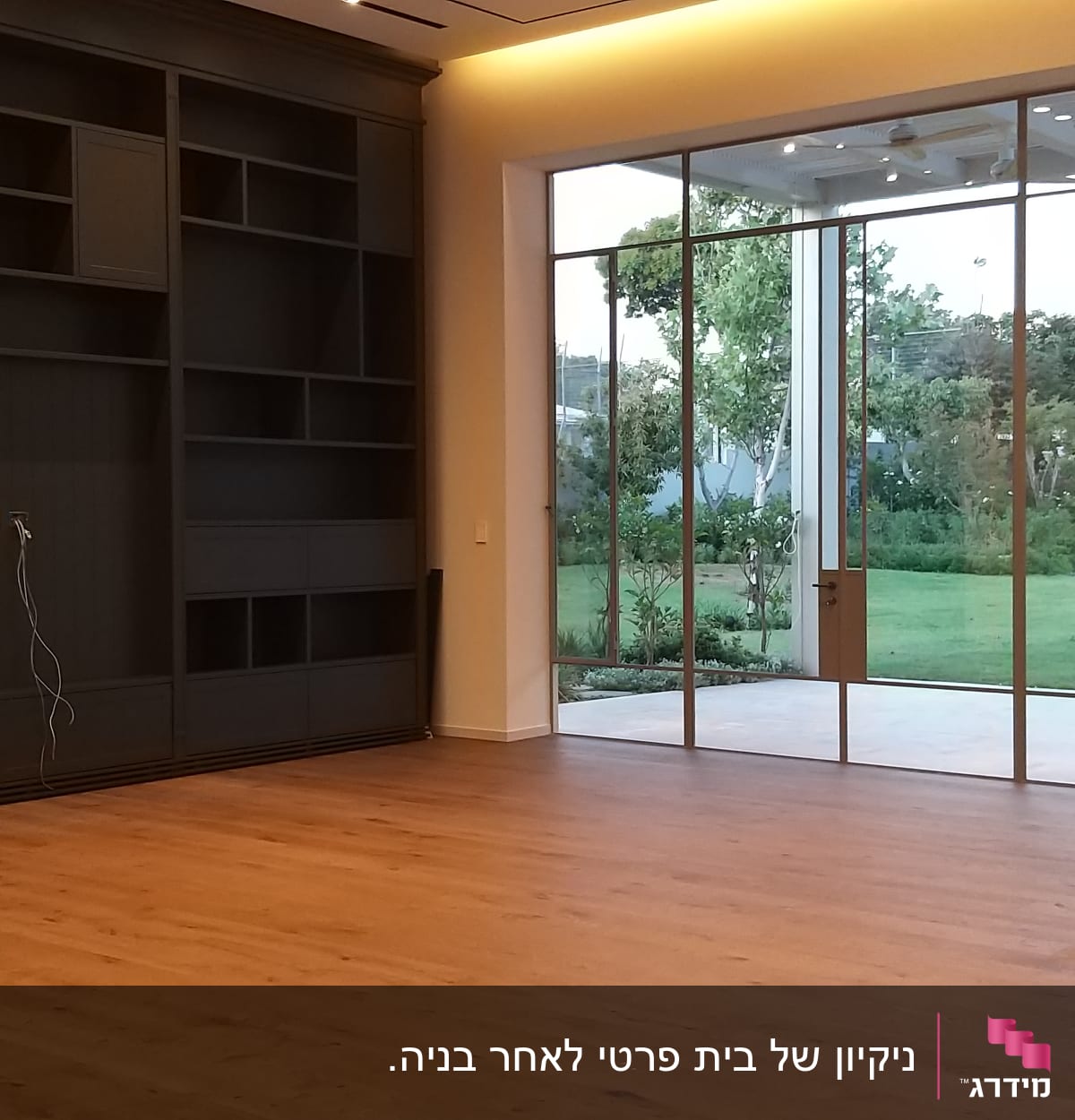 חדר ריק עם רצפת עץ וחלונות גדולים